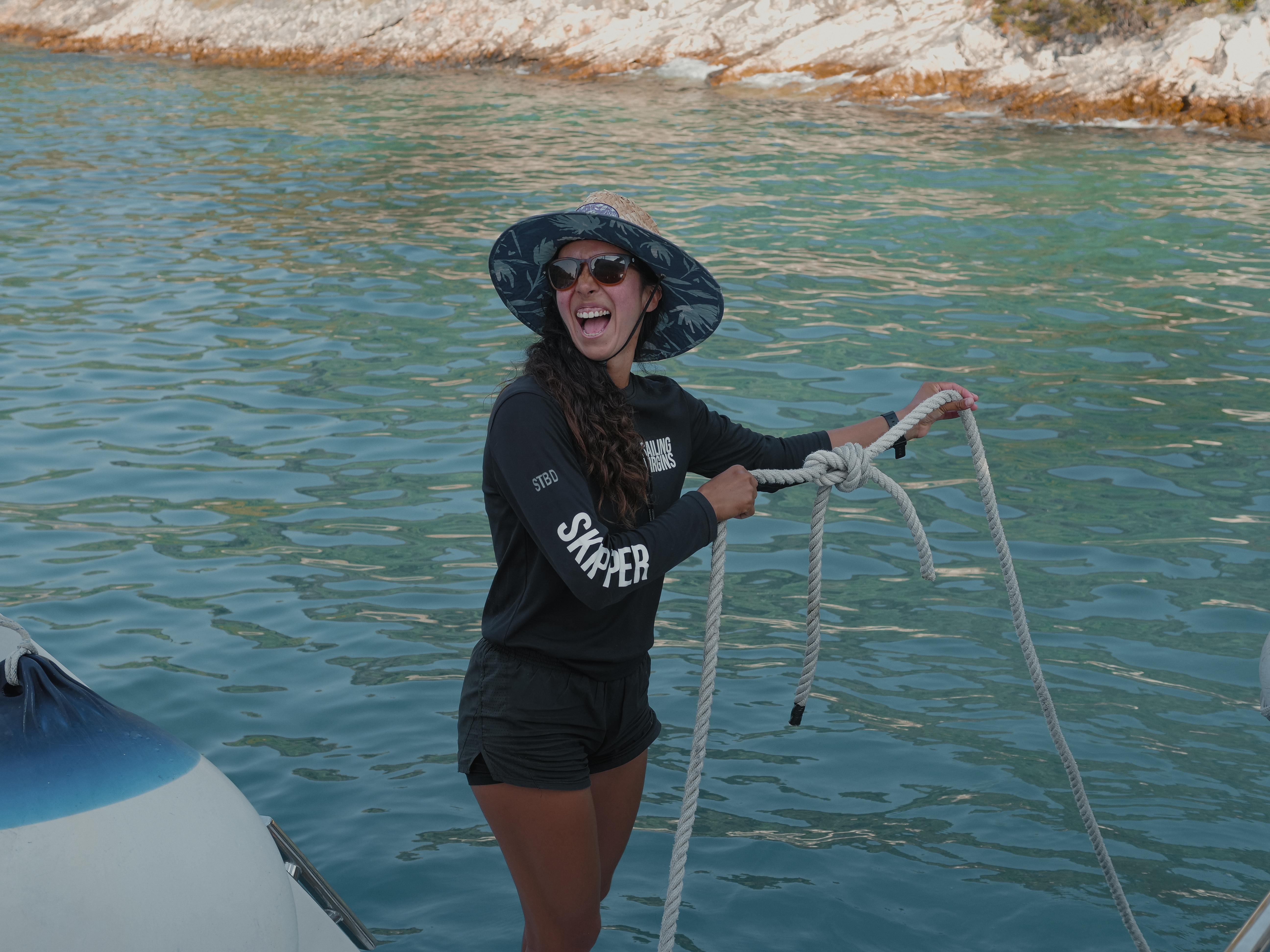 Female sailor tying two lines together